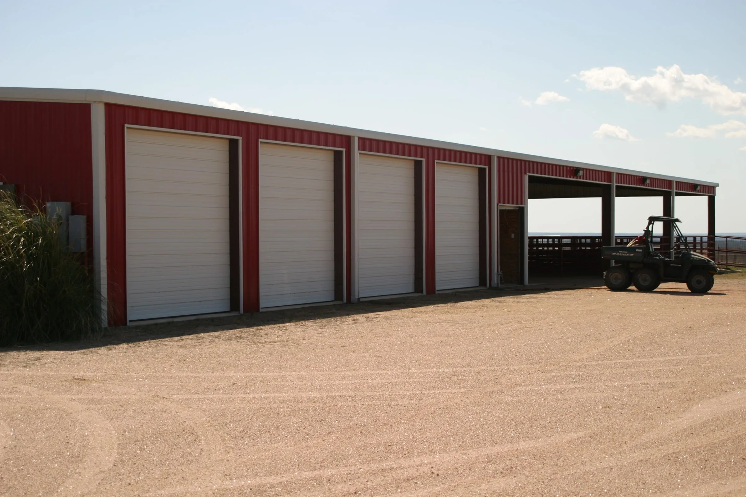 Enclosed storage with roll-up doors beside a covered canopy.