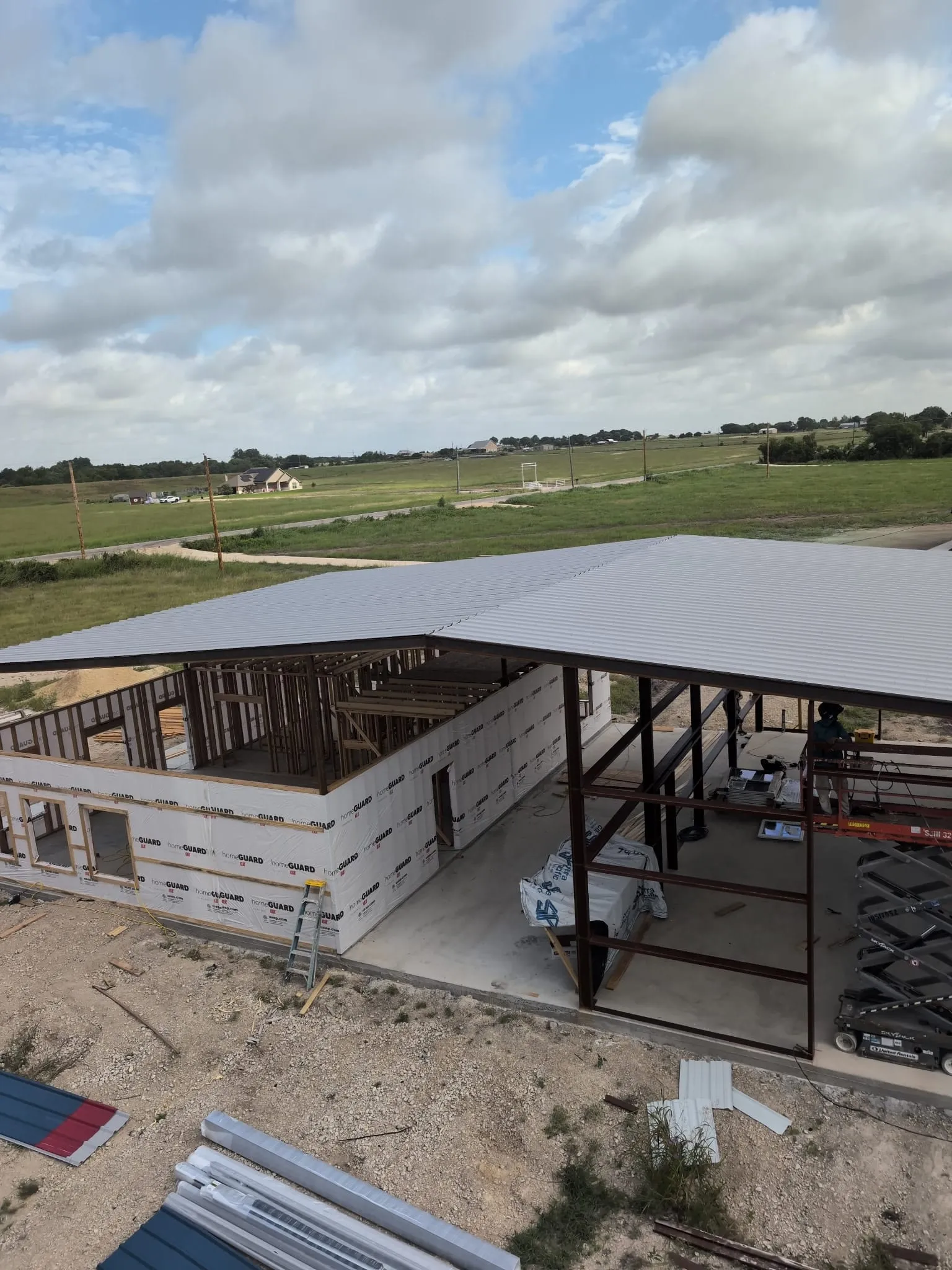 Metal roof panels installed over the wood-framed rooms below.